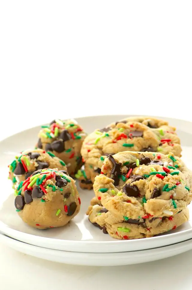 Baked cookies and cookie dough balls on a plate.