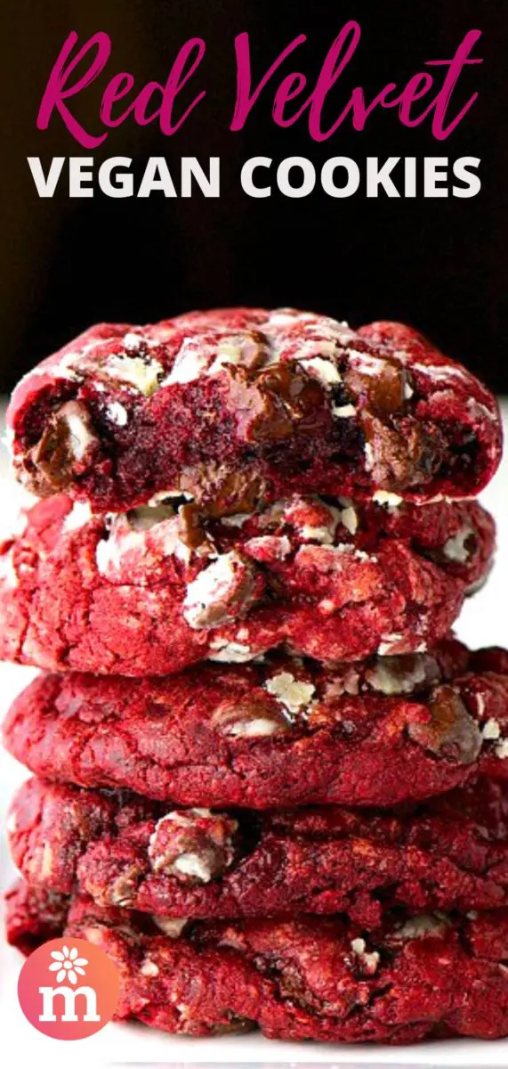 A long stack of red velvet cookies shows the top one with a bite taken out, revealing lots of melty chocolate chips inside. The text on to of the image reads, Red Velvet Vegan Cookies.