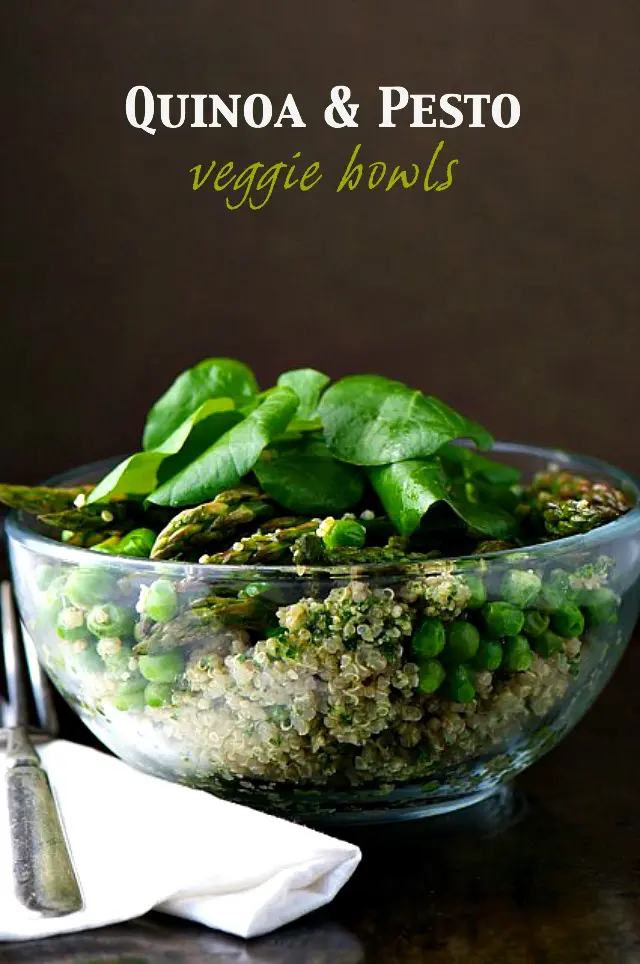 A glass bowl is full of quinoa, peas, asparagus, and topped with spinach leaves. The text at the top reads, "Quinoa & Pesto Veggie Bowls."