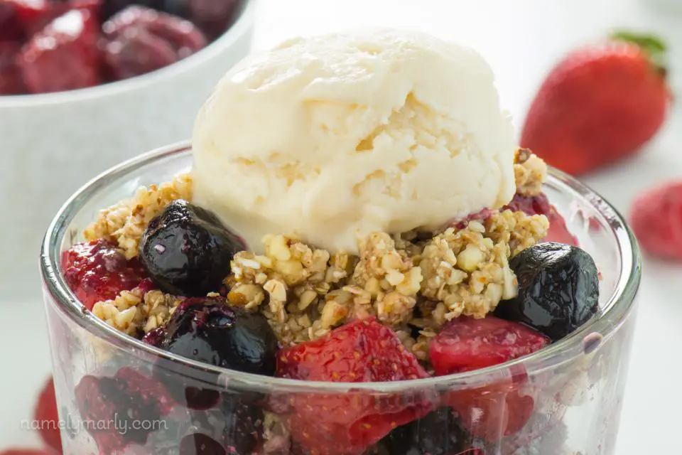 Vegan No-Bake Cherry Fruit Crisp in a serving dish with ice cream on top.