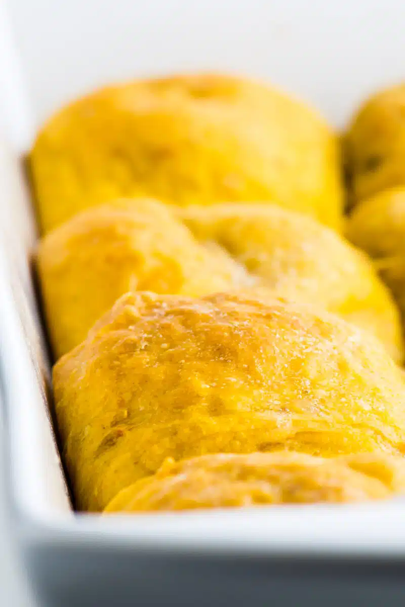 A close-up look at a sweet potato dinner roll in a baking dish pulled fresh from the oven.