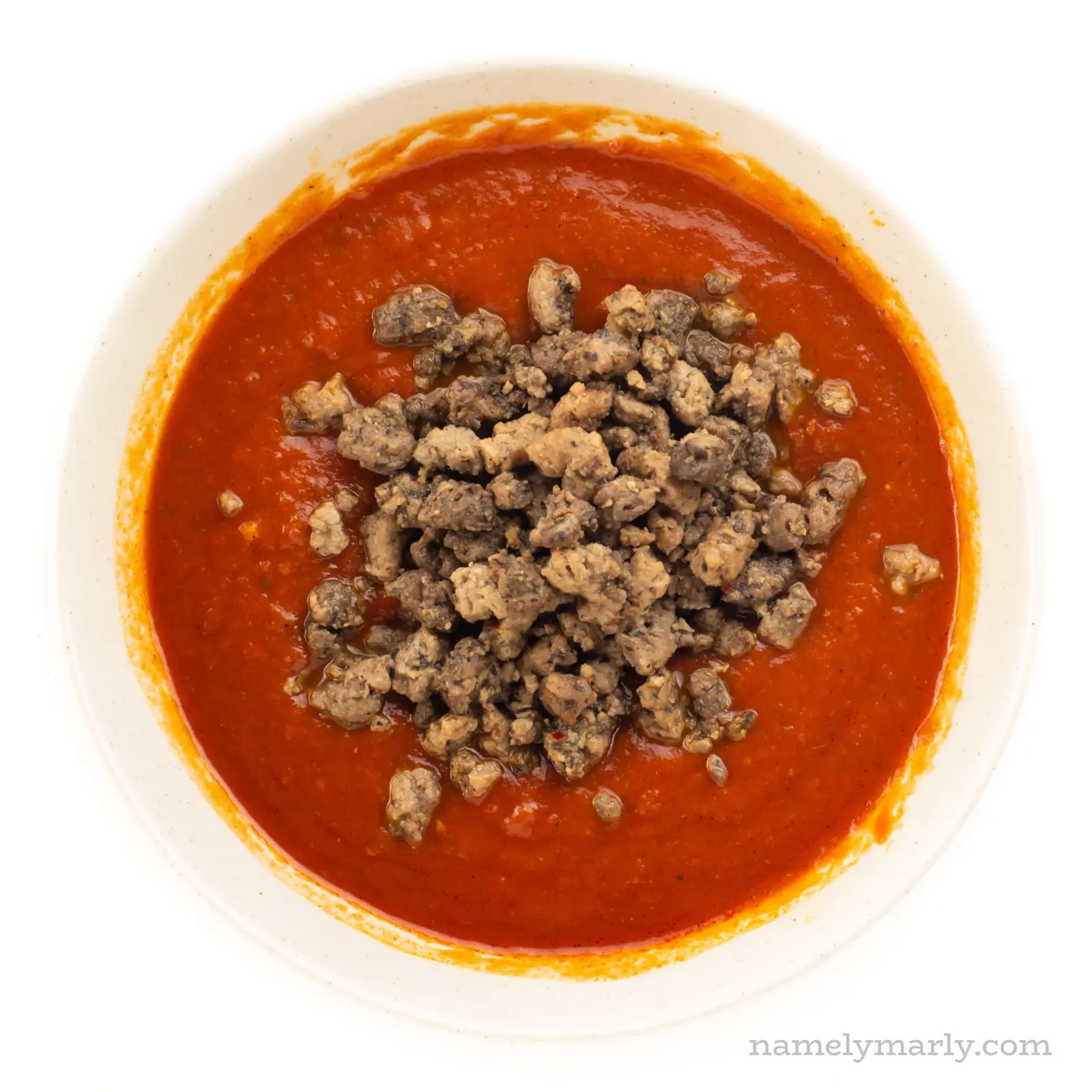 Marinara sauce in a bowl with veggie crumbles added.