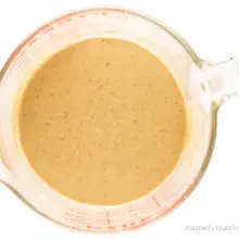 A bowl of the sauce used to make granola in a glass pyrex measuring cup.