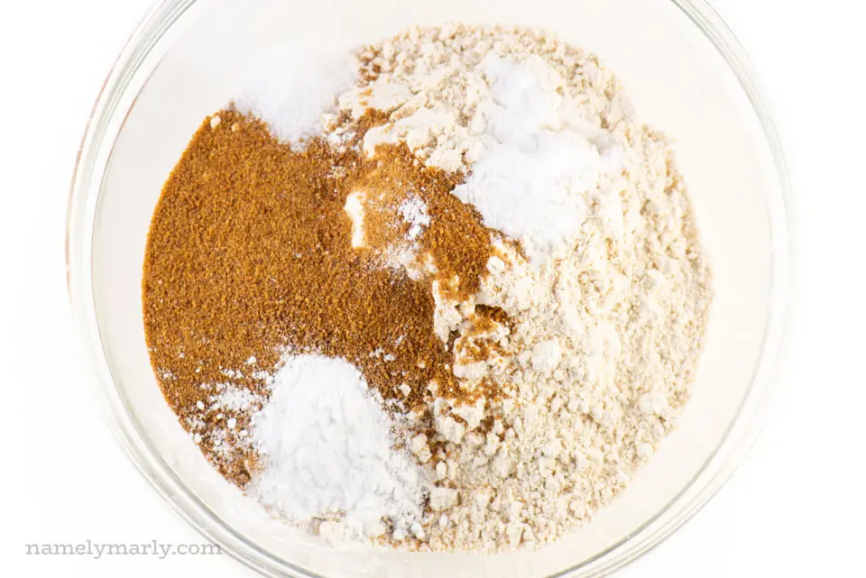 Flour, coconut sugar, and other dry ingredients for banana muffins in a bowl.