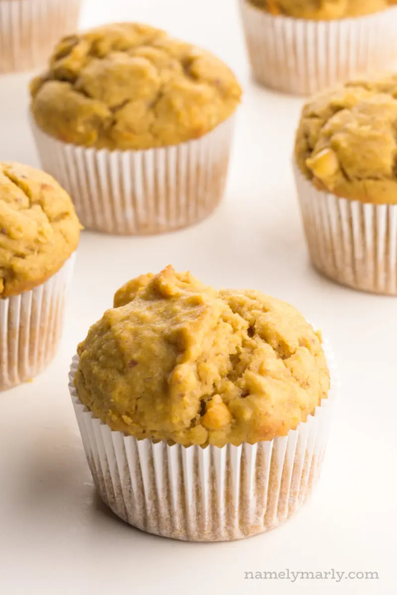 Several peanut butter muffins sit on a white counter top.