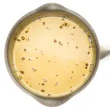 Vegan cream and sugar has been added to a saucepan. It is a light golden color.
