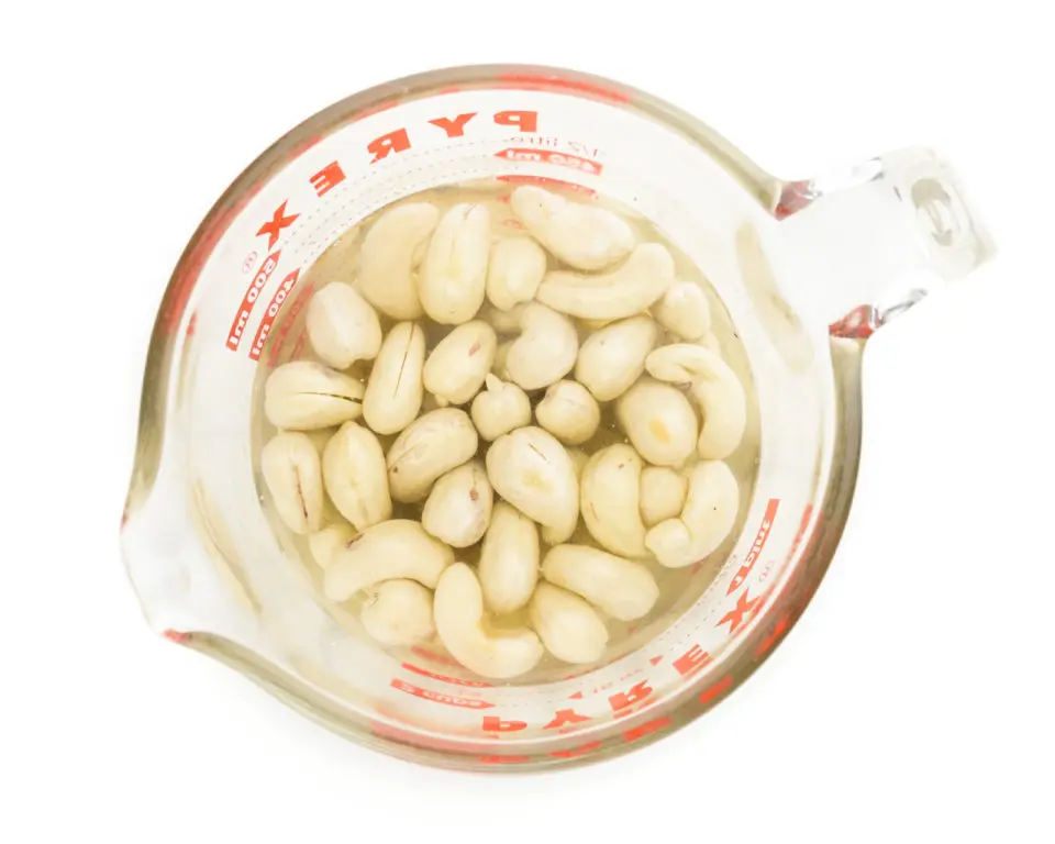 Cashews are soaking in water in a glass pyrex measuring cup.