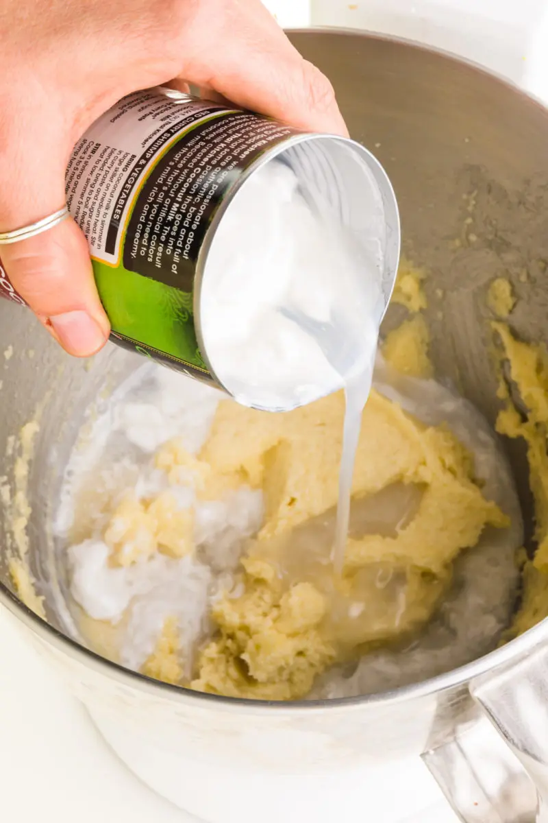 A can of fun fat coconut is being poured into a mixing bowl.