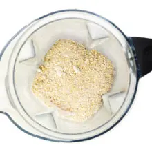 Blended oat flour is in the bottom of a blender jar, having recently been blended.
