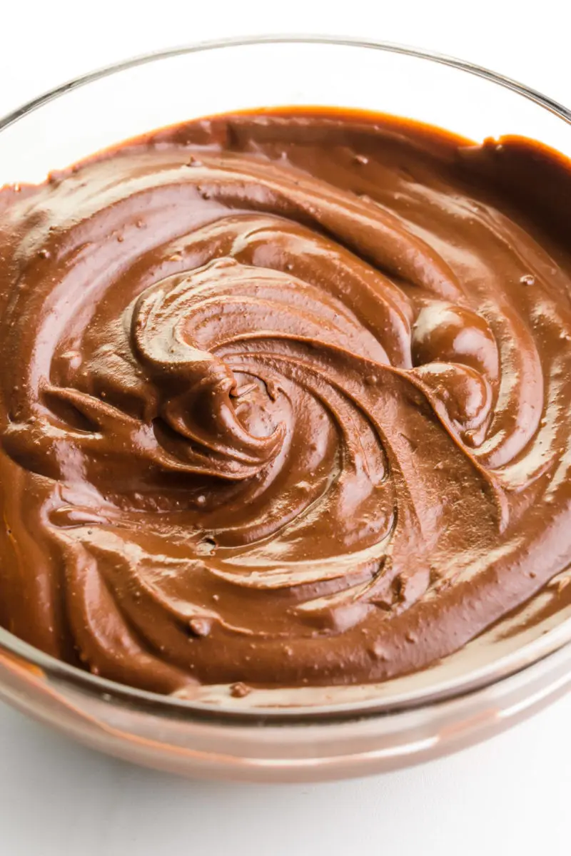A close-up shot of vegan ganache in a bowl. The light is playing off the swirls of chocolate.