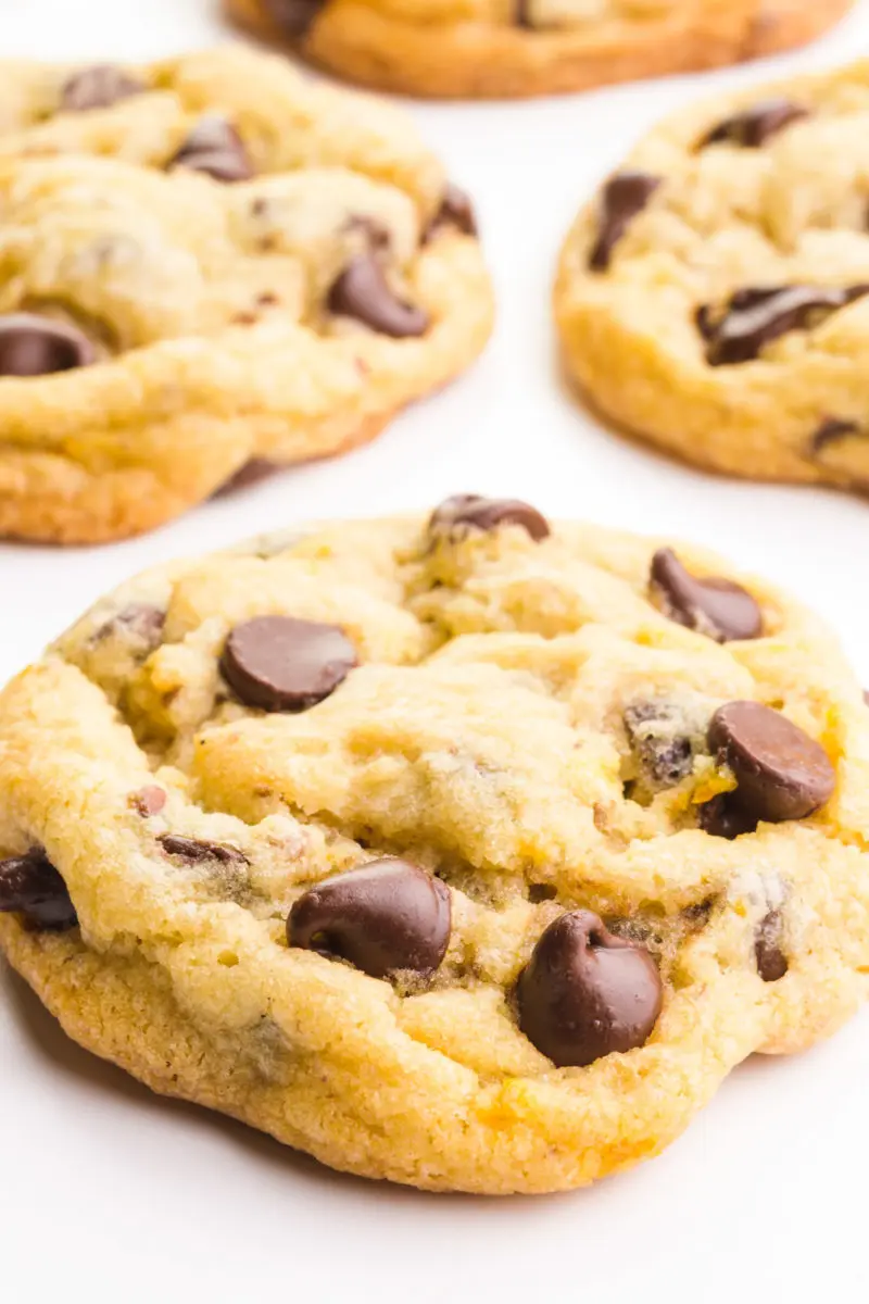 A chocolate chip cookie shows melted chocolate chips. There are more cookies in the background.