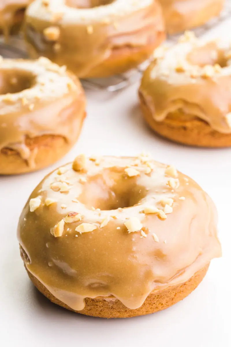 A vegan caramel donut sits in the foreground with several more donuts in the background.