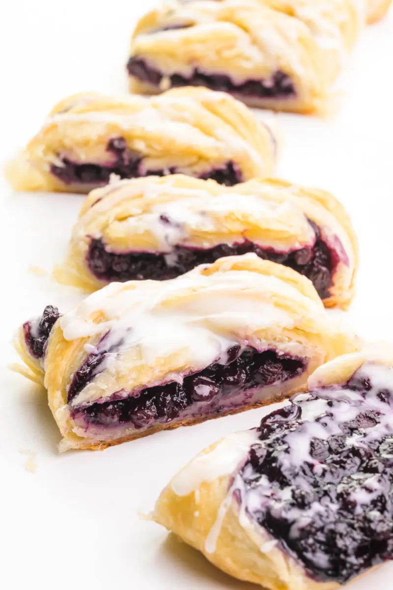 A vegan danish has been cut into pieces, showing lots of blueberry filling.