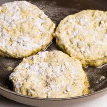 Breaded tofu patties are frying in a skillet.