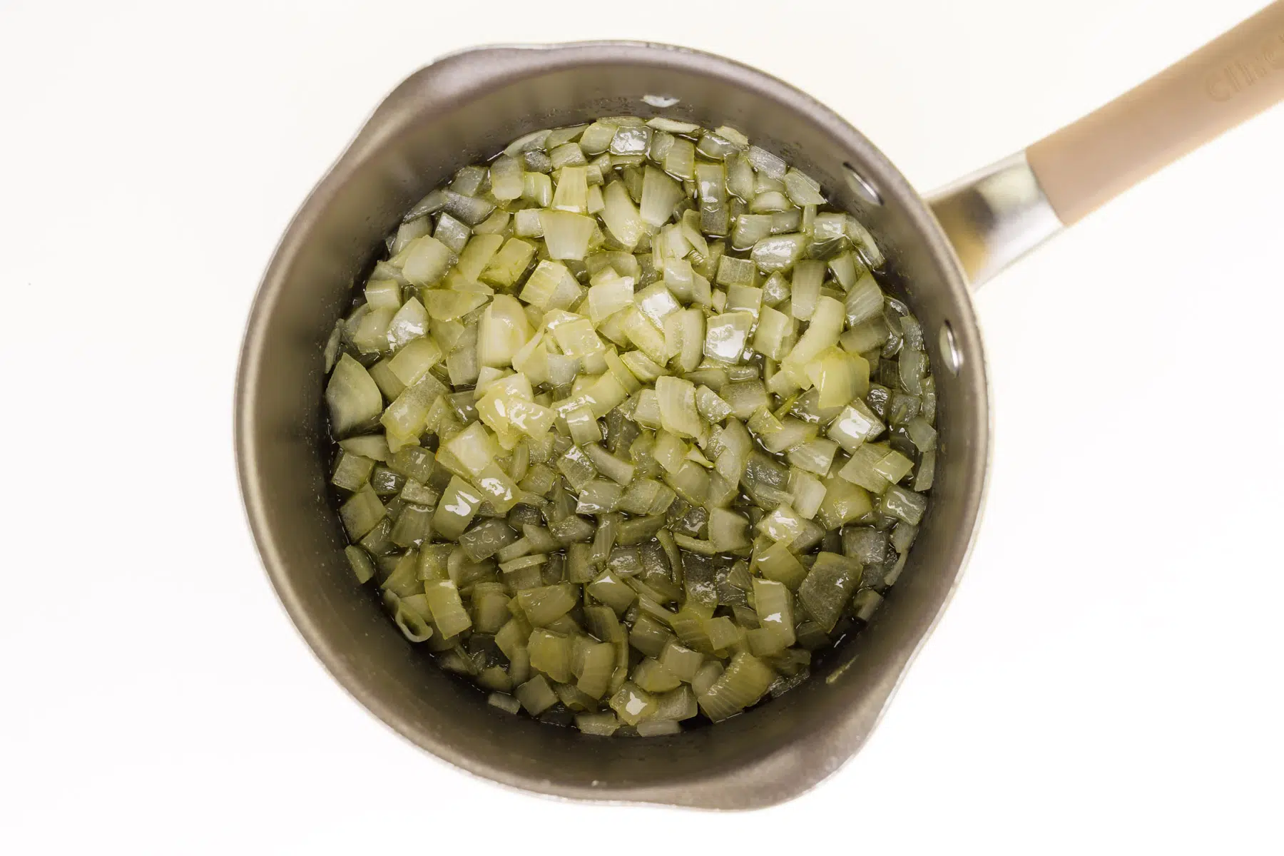 Chopped onions are cooking in the bottom of a saucepan.