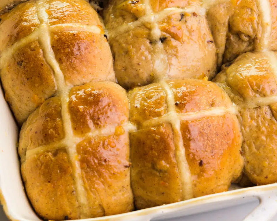 Looking down on hot cross buns freshly baked in a baking dish.