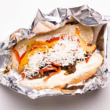 A vegan cheesesteak sandwich sits in foil waiting to be baked.
