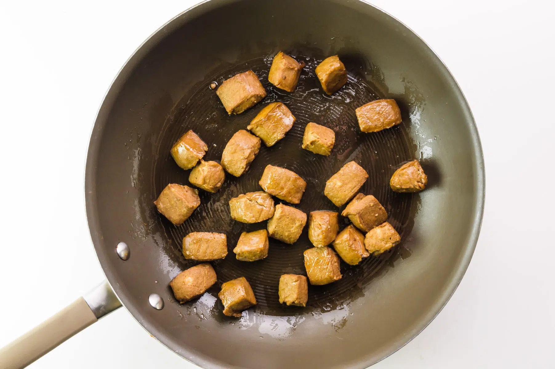 Vegan beef tips are being cooked in a skillet.