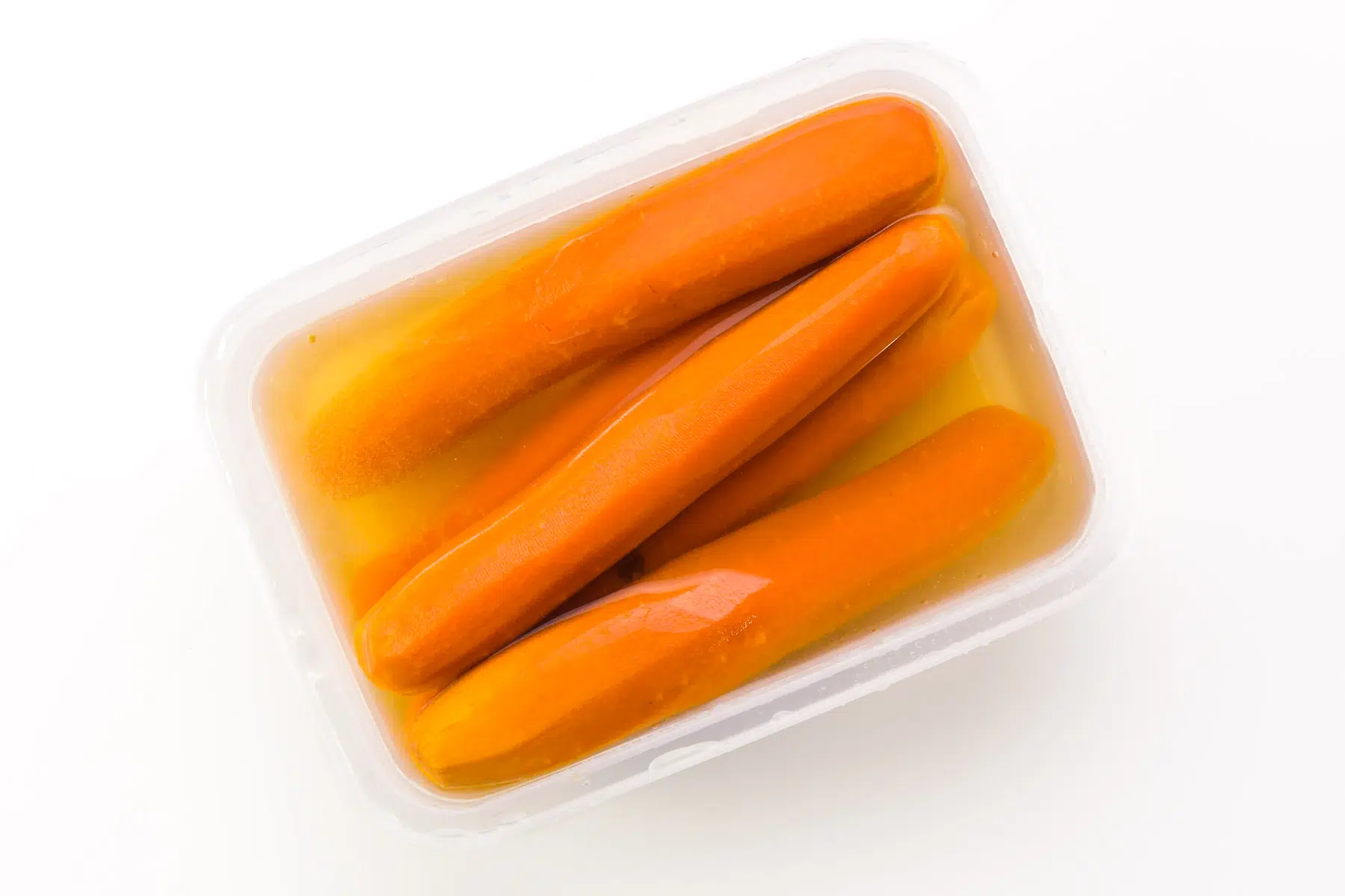 Carrots are being cooled in water in a storage container.