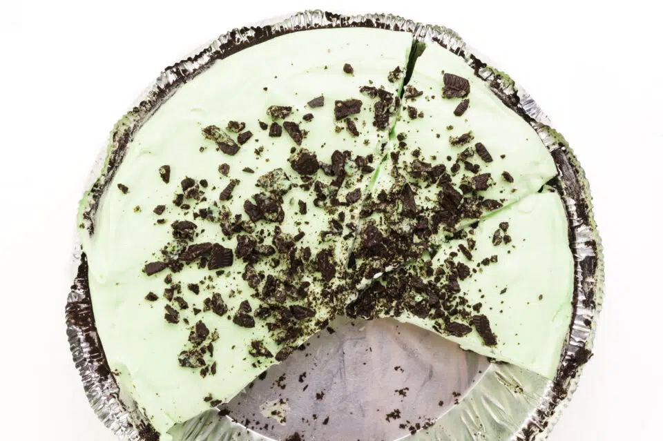 Looking down on a vegan grasshopper pie with a few slices cut out.