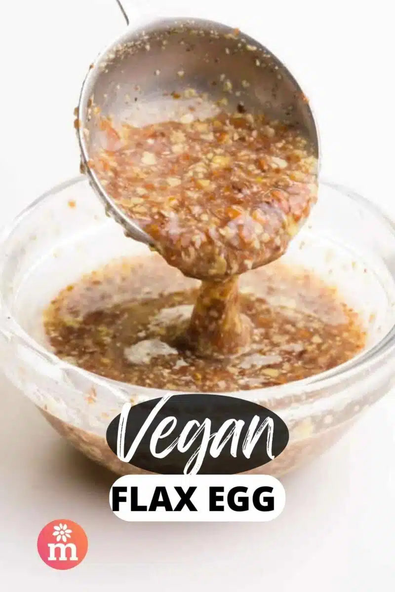A spoon holds a brown gooey mixture over a bowl. The text reads Vegan Flax Egg.