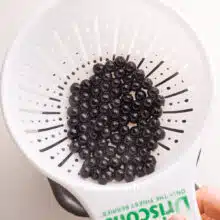 Freshly cooked boba pearls are in a strainer.