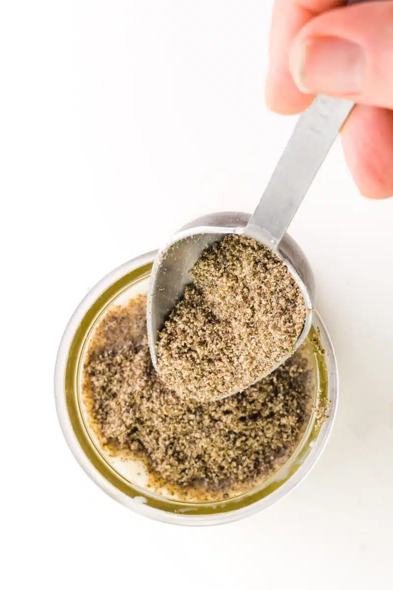 A hand pours ground chia seeds into a bowl.