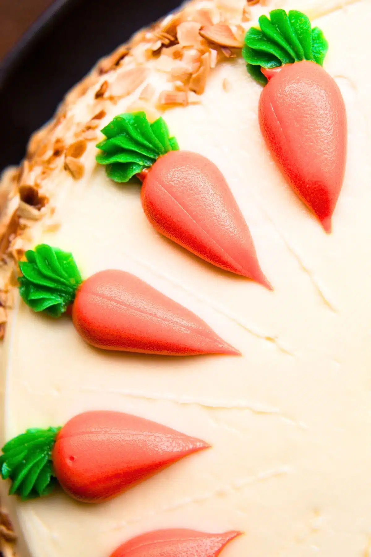 Looking down on a carrot cake with icing carrots on top.