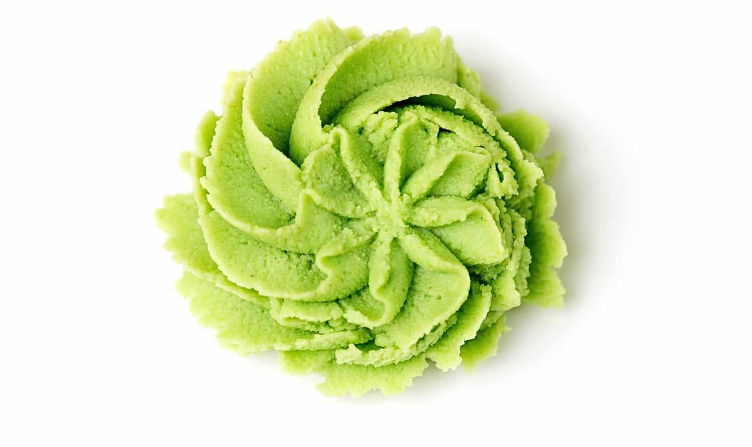 Looking down on wasabi paste that has been pressed from a frosting bag using a star tip, leaving behind a decorative flower-like shape.