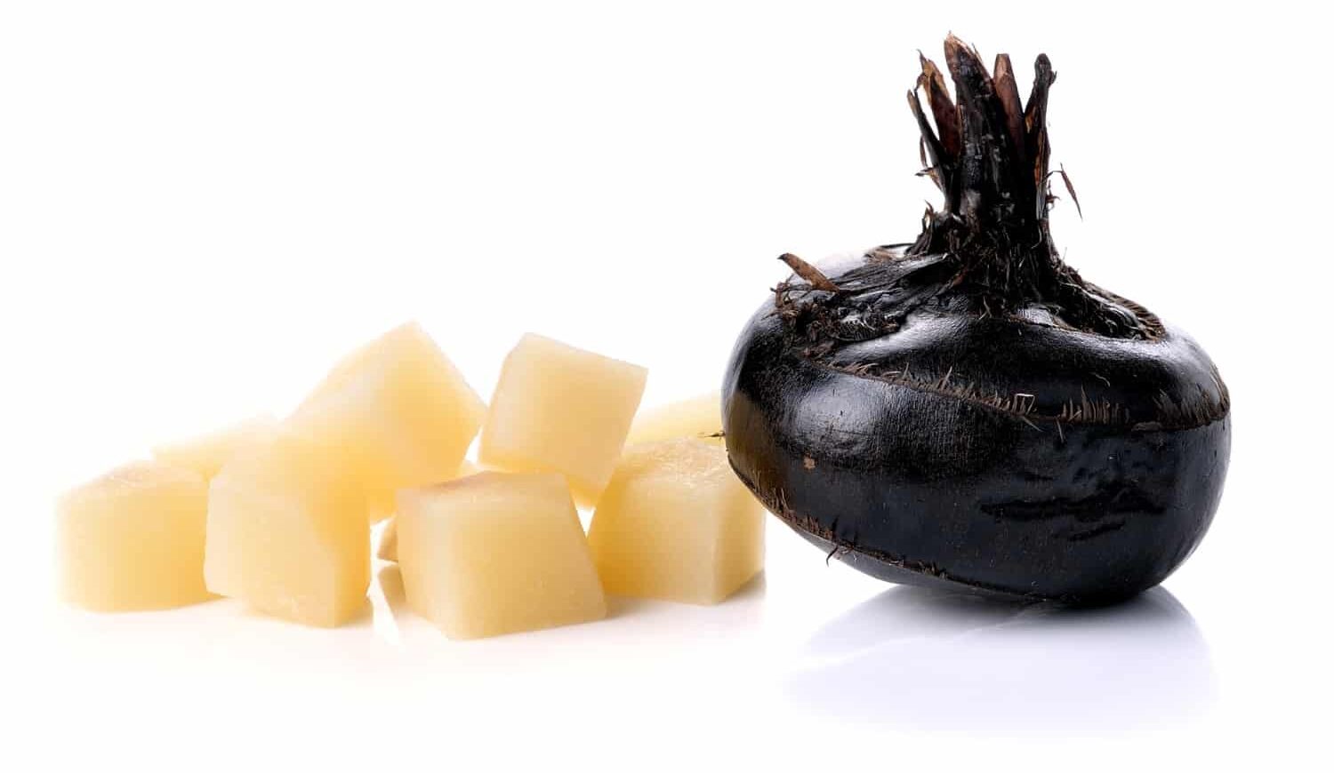 A whole black water chestnut sits next to cubes of the vegetable that has been skinned and ready for adding to stir-fries.