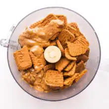 Biscoff cookies are in a food processor along with some almond butter.