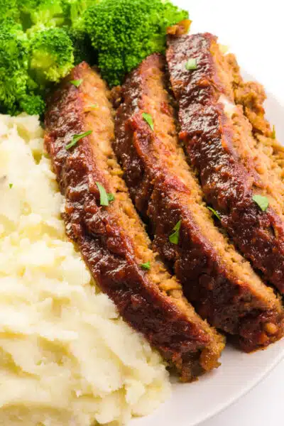 Slices of Impossible meatloaf sit next to mashed potatoes and steamed broccoli.